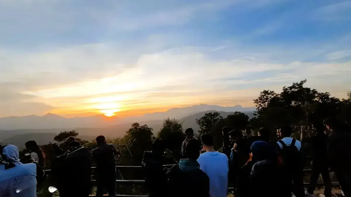 Visitors watching the sunset from a viewpoint in Pachmarhi