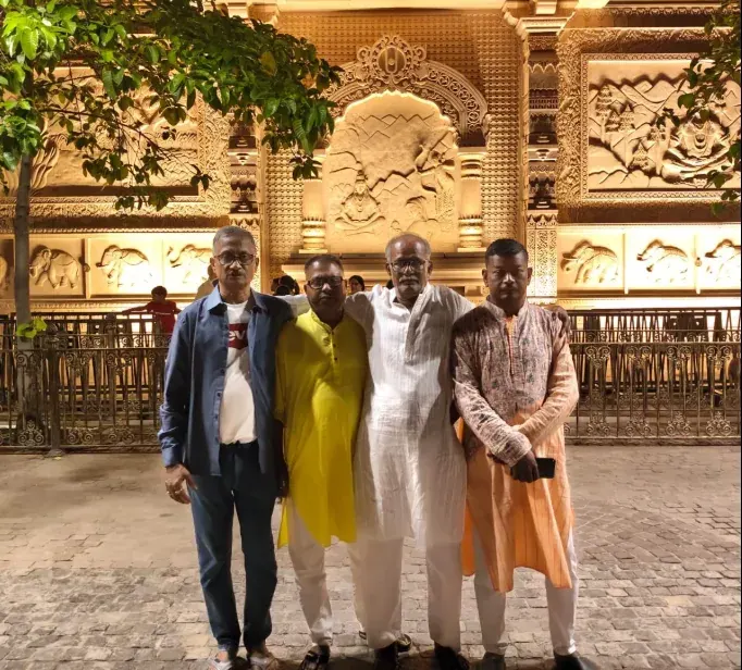 Guests in front of a carved temple wall in the evening