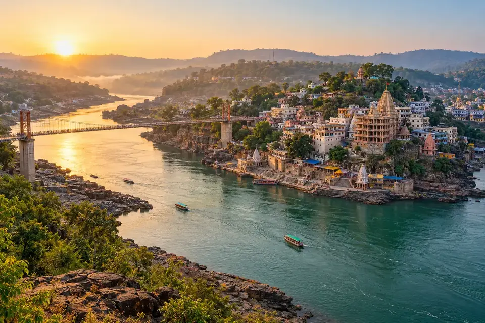 Photo-style AI visualisation of Omkareshwar temple-town, Mandhata island, the Narmada and a pedestrian bridge